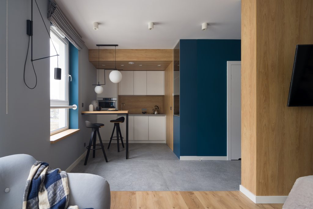 Modern kitchen open to room with cozy armchair